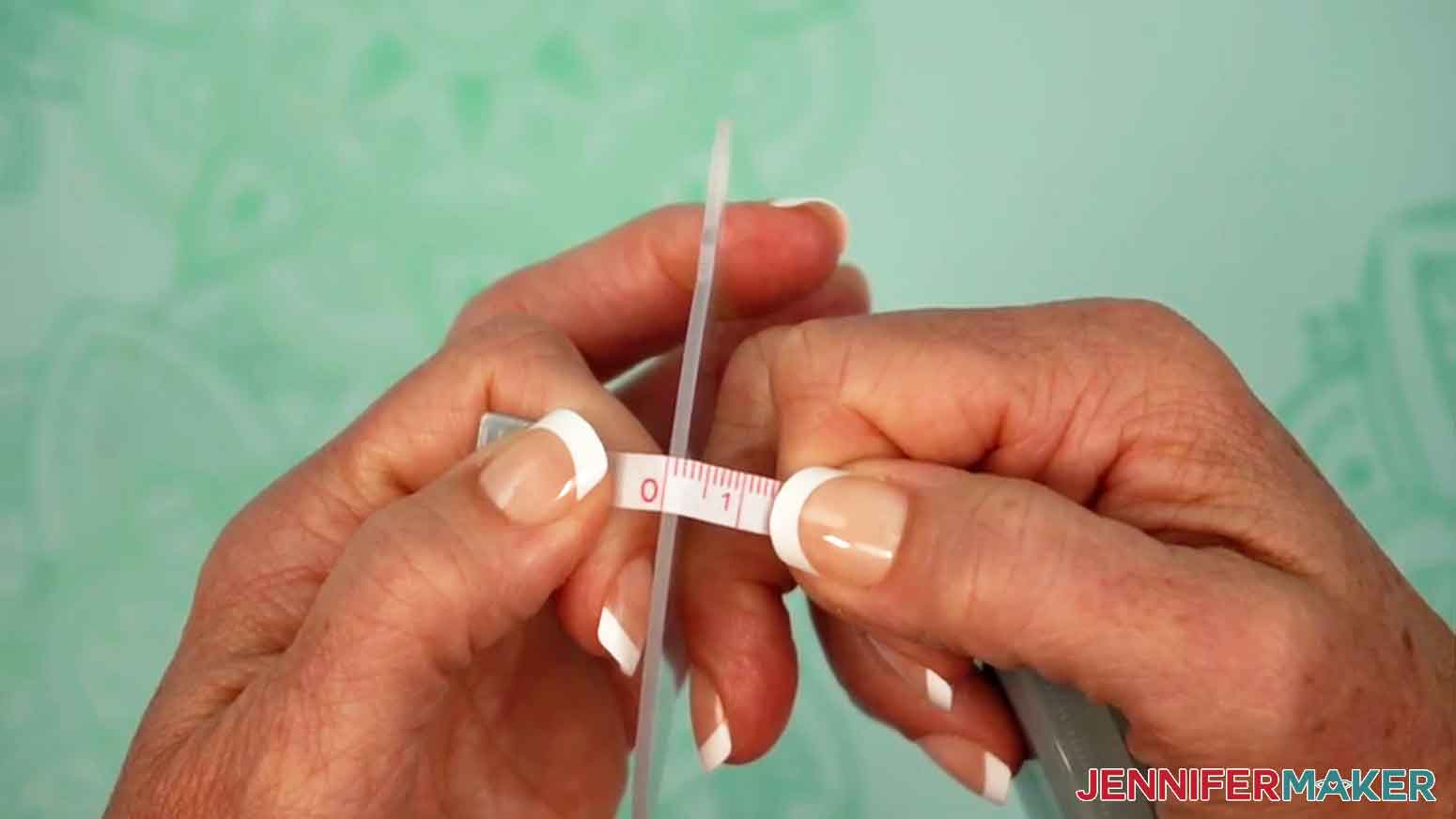 A tape measure is being use to measure the thickness of the acrylic ornament.