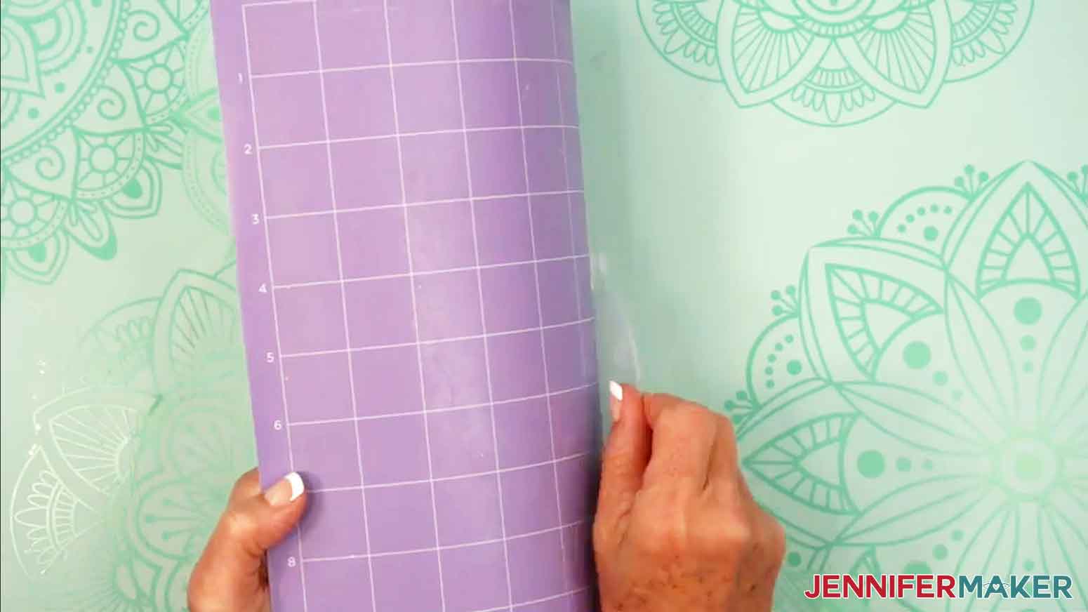 The acrylic blank is being removed from the purple strong grip mat by rolling the mat away from the blank.