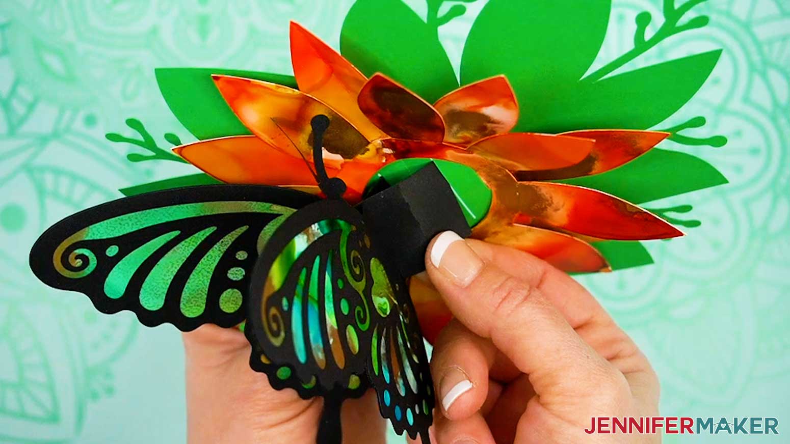 Slot the butterfly's tabs into the largest slots on the pop up card's foliage piece.