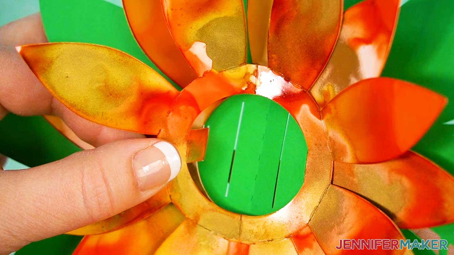Slot the tabs on the top flower petal piece into the second small slots on the pop up card's foliage piece.