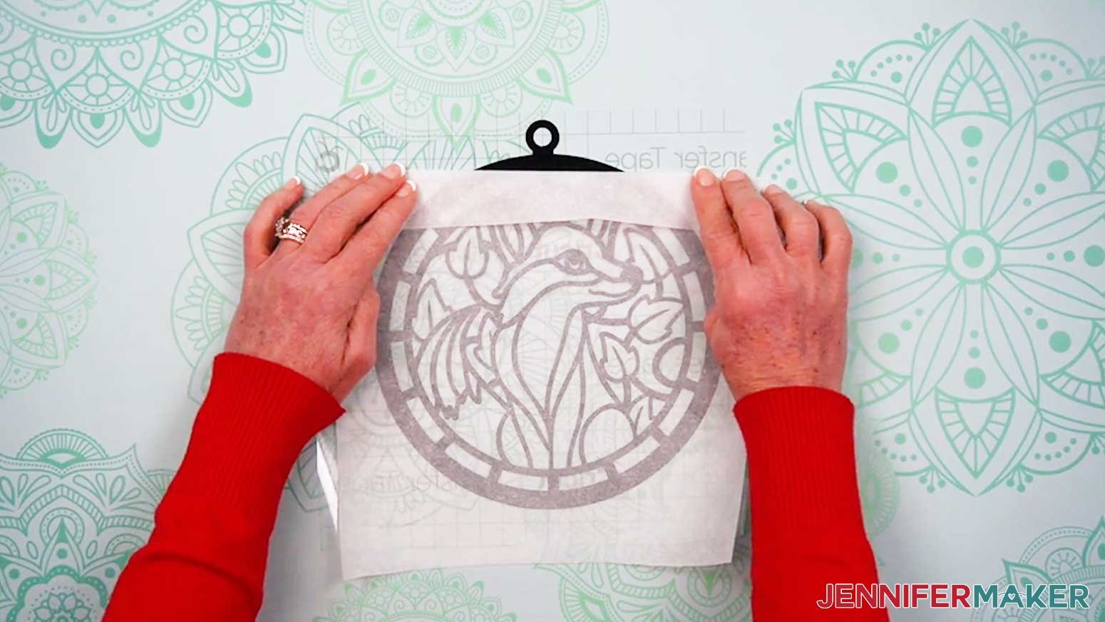 Peel back the top of the parchment to expose the hanger and upper curve of the vinyl Alcohol Ink Stained Glass design layer.