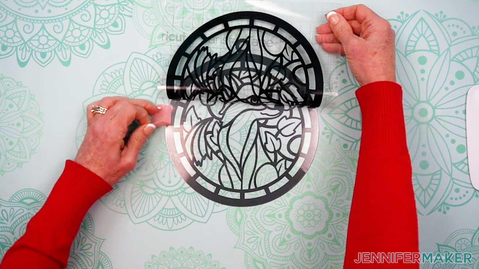 Remove the painter tape as the vinyl layer is applied to the previously stacked acetate and vinyl layers for the Alcohol Ink Stained Glass design.
