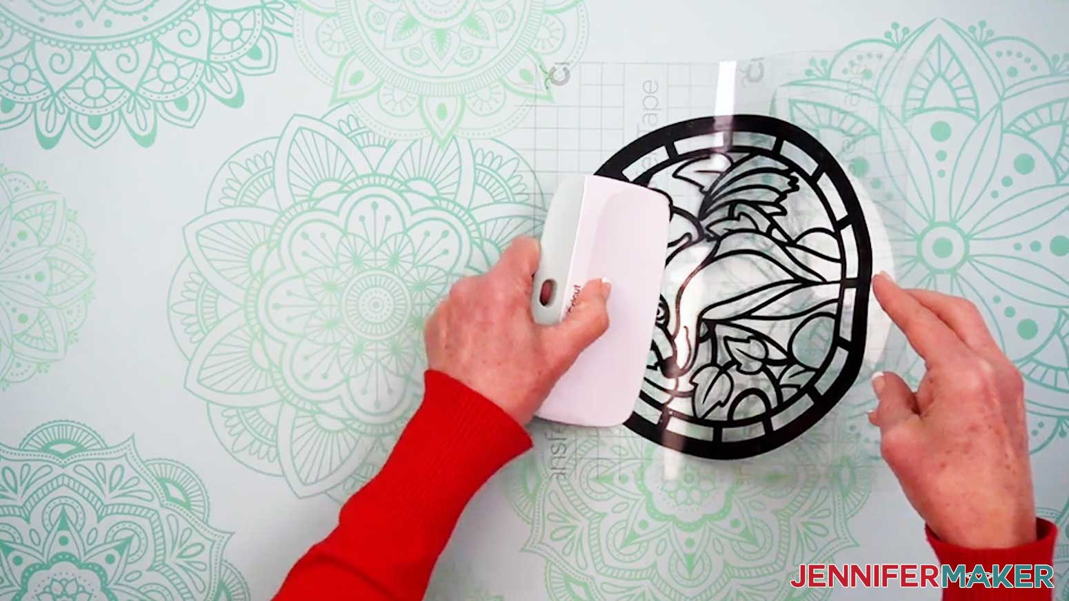 Use a scraper to burnish the vinyl layer of the Alcohol Ink Stained Glass design to the acetate layer.