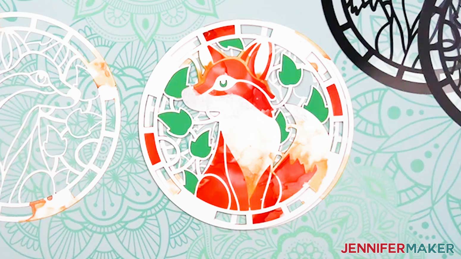 Adhere the white layer of the fox design to the stack of pieces for the Alcohol Ink Stained Glass design.