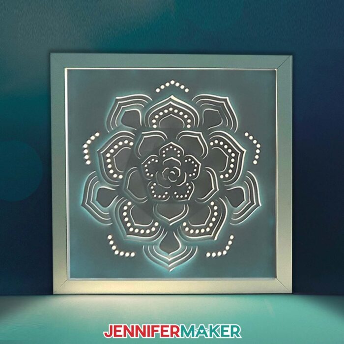 A Shadow Box project featuring a papercut succulent design glows in from inside a square white frame