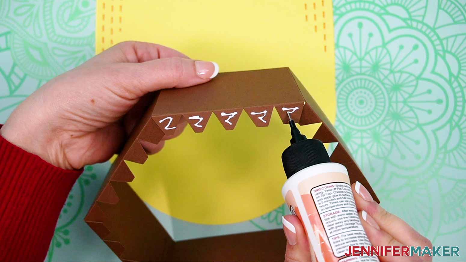 Apply craft glue along the bottom tabs of the back gift box side panel.
