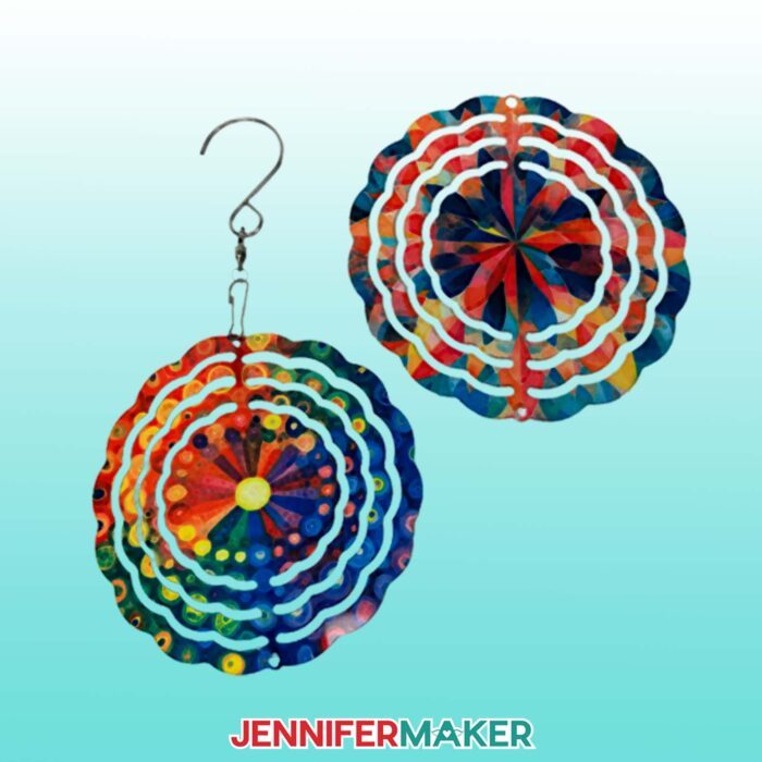 Two miniature wind spinners from the Beginner Sublimation Kit decorated with bright colors sit on a teal surface