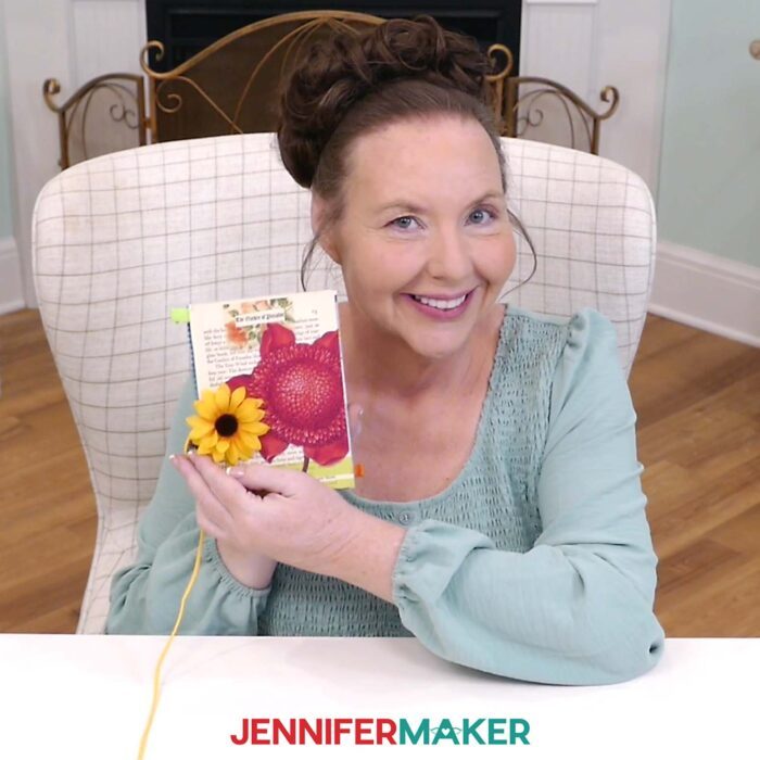 Jennifer holds up a flat card adhered together using craft glue