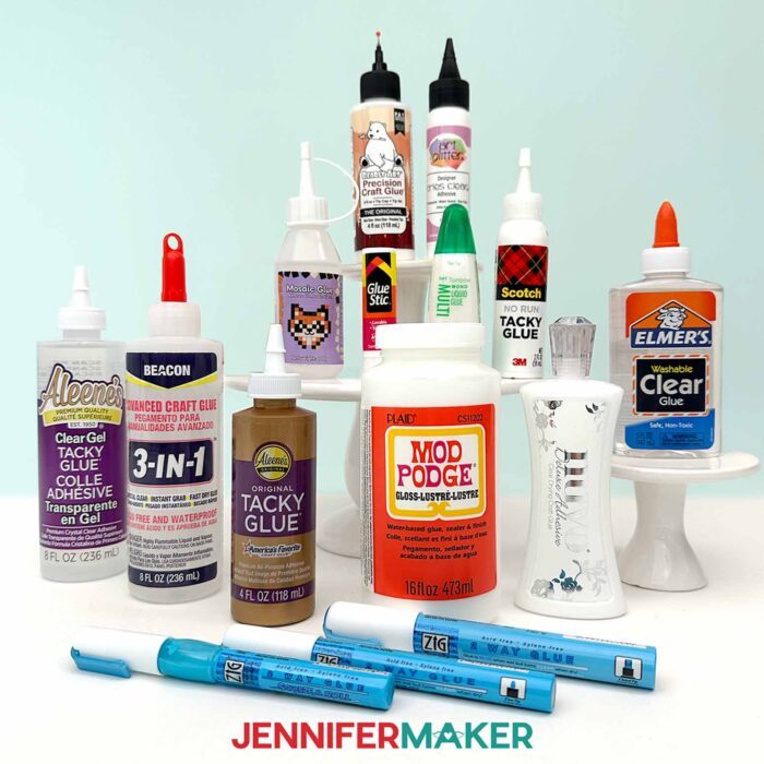 All the glues Jennifer tested on display: Bearly Art, Art Glitter Glue, Mosaic Glue, Avery Permanent Glue Stick, Tombow Liquid Glue, Scotch No-Run Tacky Glue, Aleene's Clear Gel, Beacon 3-in-1, Aleene's Tacky Glue, Mod Podge Gloss, Nuvo Deluxe Adhesive, Elmer's Clear Glue, Zig Glue Pens in 4mm, 2mm, and 1mm 