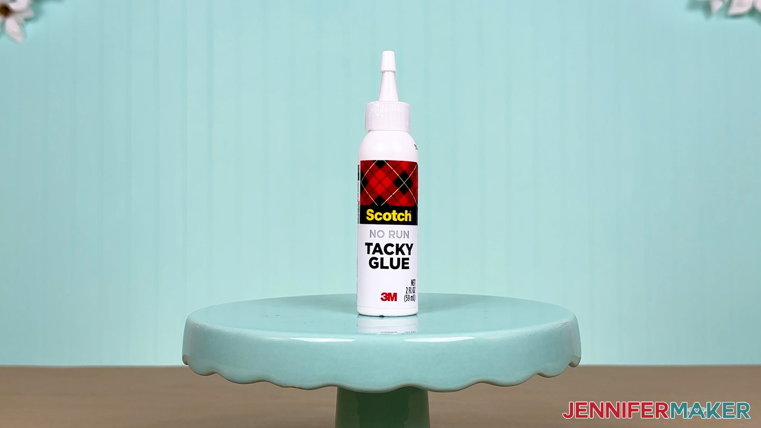 The Scotch No Run Tacky Glue bottle is arranged on a display table for the Best Craft Glues test.