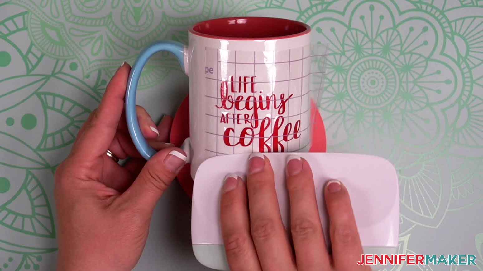 Use a scraper tool over the strong grip transfer tape to adhere red shimmer vinyl to the coffee mug.