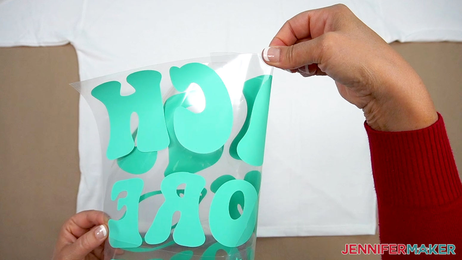 Fold the design in half and pinch the carrier sheet at the top of the middle to mark the center of the design.