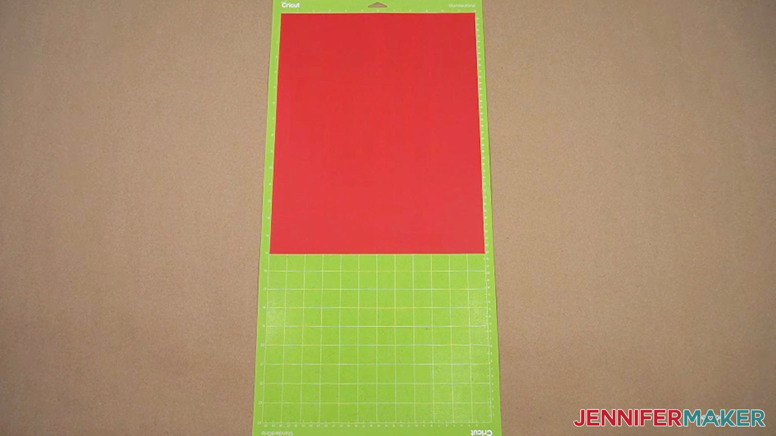 The red heat transfer vinyl is placed onto the larger machine mat and ready to cut.