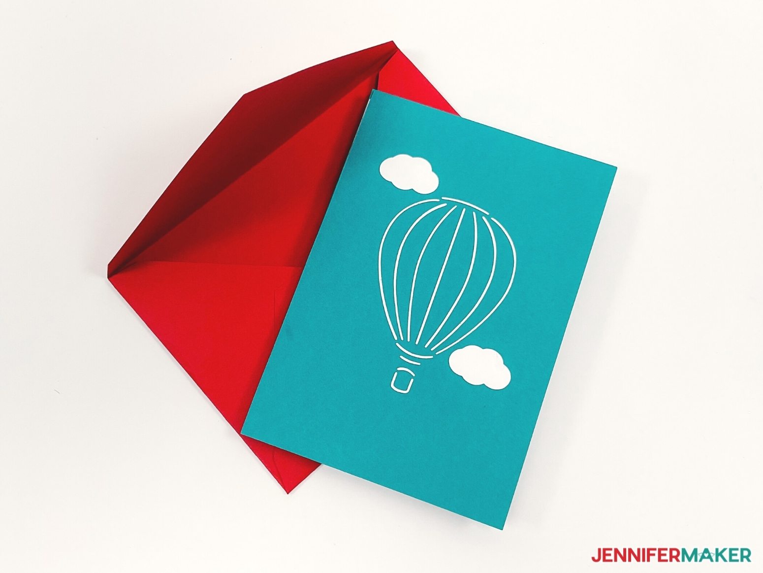 Image showing closed pop up card laying on top of custom made red envelope.