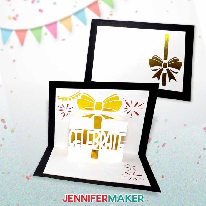 A birthday pop-up card designed by JenniferMaker. A black card with a white liner. On the outside there is a shiny gold bow. On the inside there is a shiny gold gift with the word "Celebrate" popped up. Streamers and fireworks surround the gift.