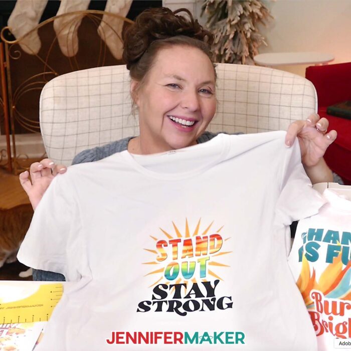 Jennifer holds up a white T-shirt with the words "Stand Out, Stay Strong" sublimated on the front.