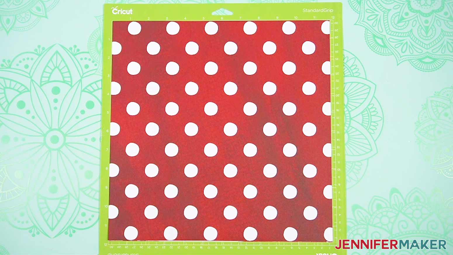 The double layered patterned cardstock is placed on the green machine mat and ready to cut for the gift bow for the busted canvas.