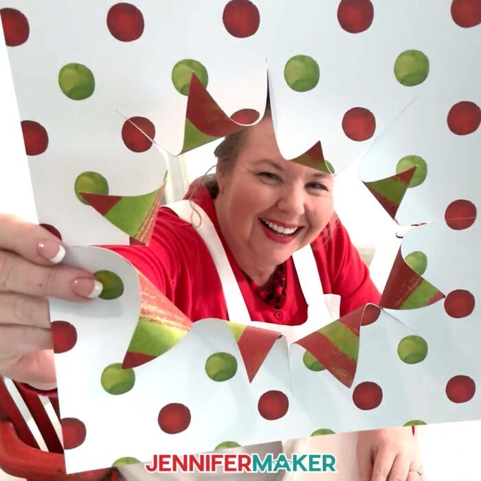 Jennifer Maker peeking through colorful cardstock cut for the front of a busted canvas.
