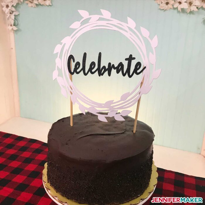 A chocolate cake with a white "Celebrate" DIY cake topppere