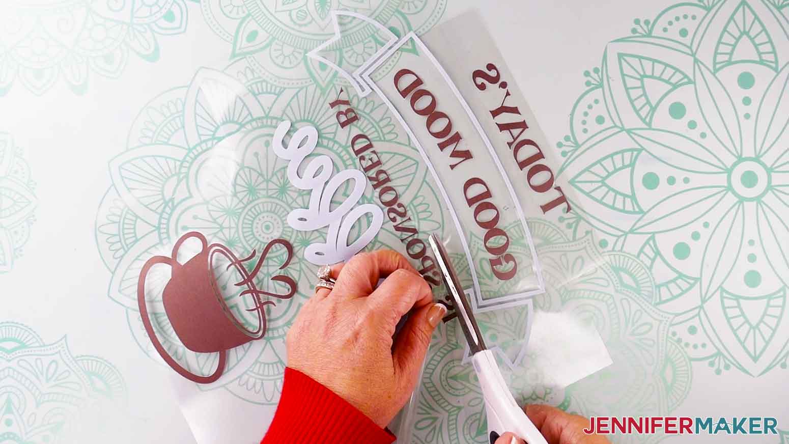 Use scissors to trim the infusible ink carrier sheet under the teal banner.