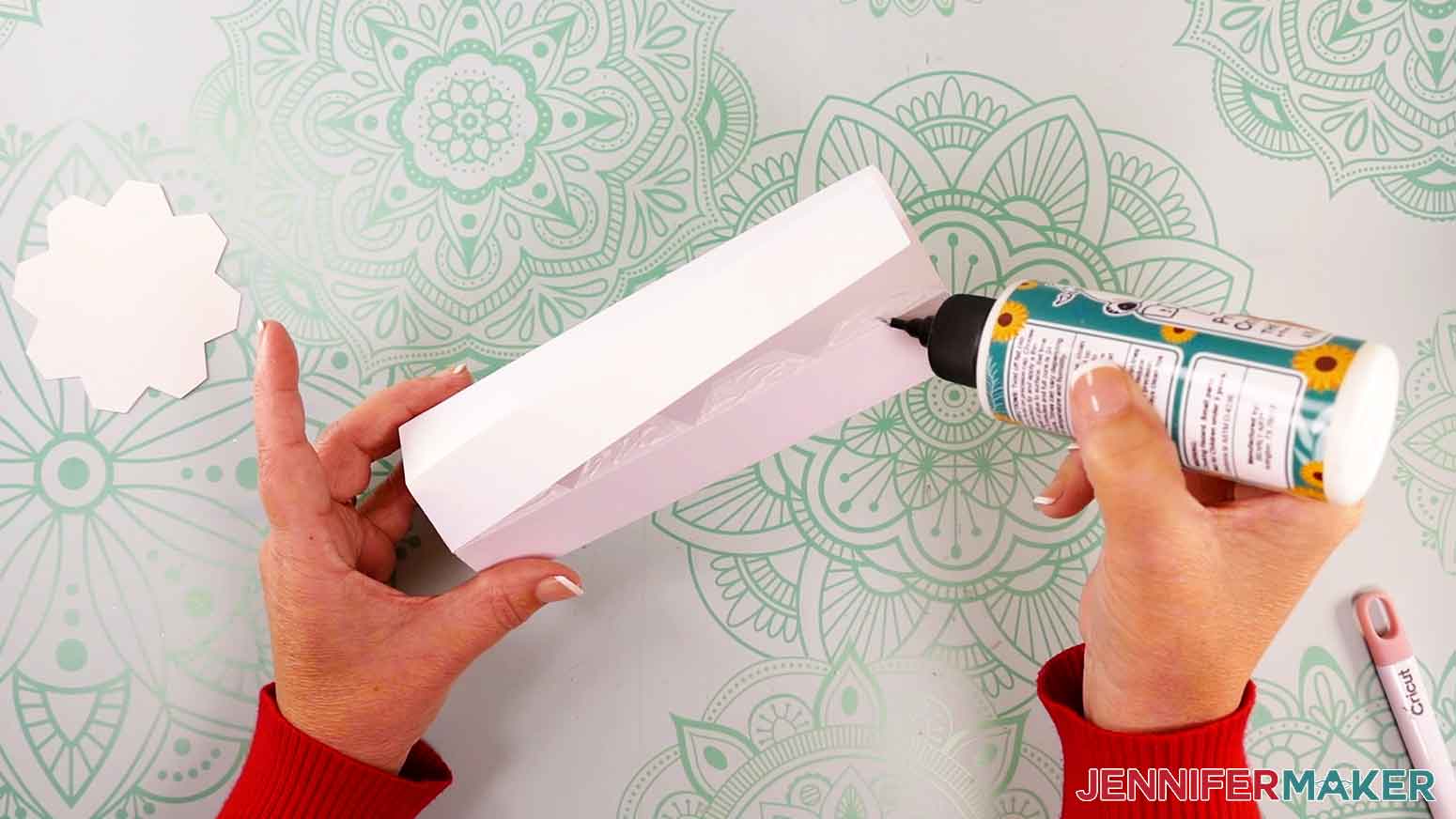 Add glue to the tabs of the candle body.