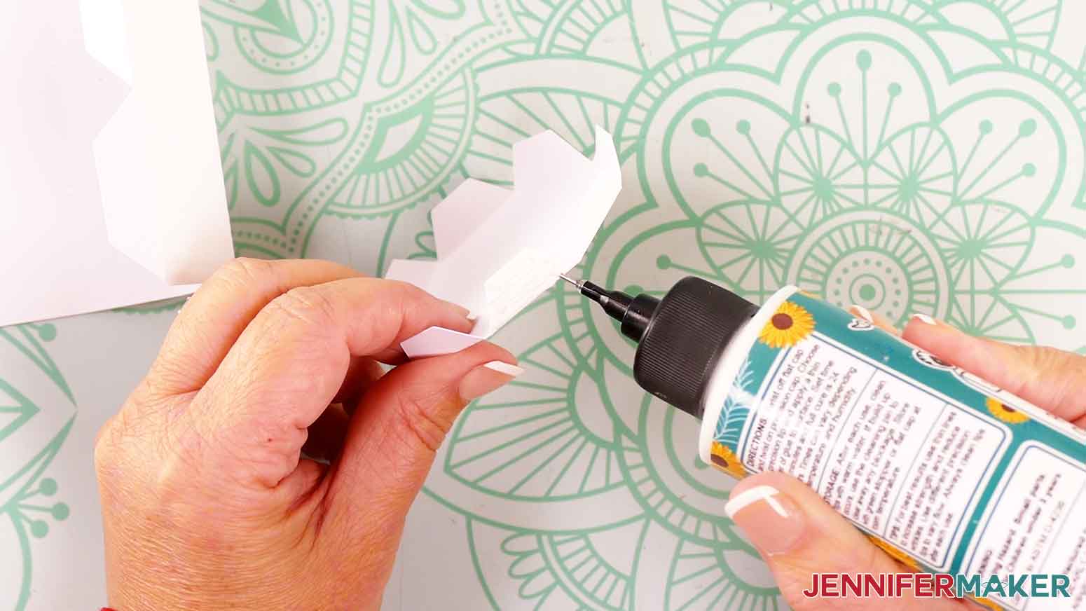 Apply glue to the outside of one of the candle bottom tabs.