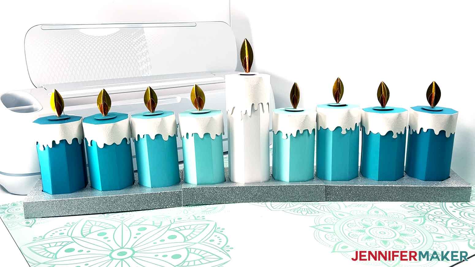 Finished candle gift boxes in different shades of blue and white. There is one tall candle and eight smaller candles to represent a menorh.