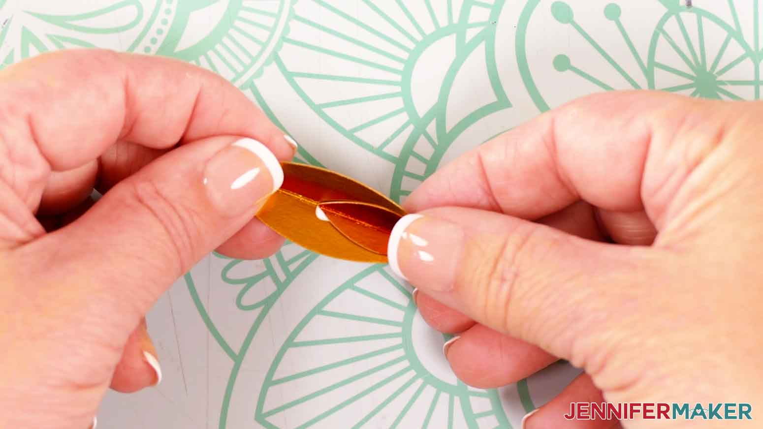take a small flame piece and, aligning the folds, press it onto the glue at the end of the large piece.