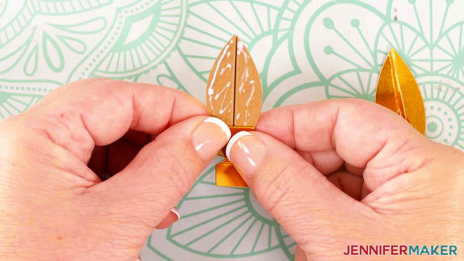 Press the support piece onto the glue near the bottom of the flame piece.