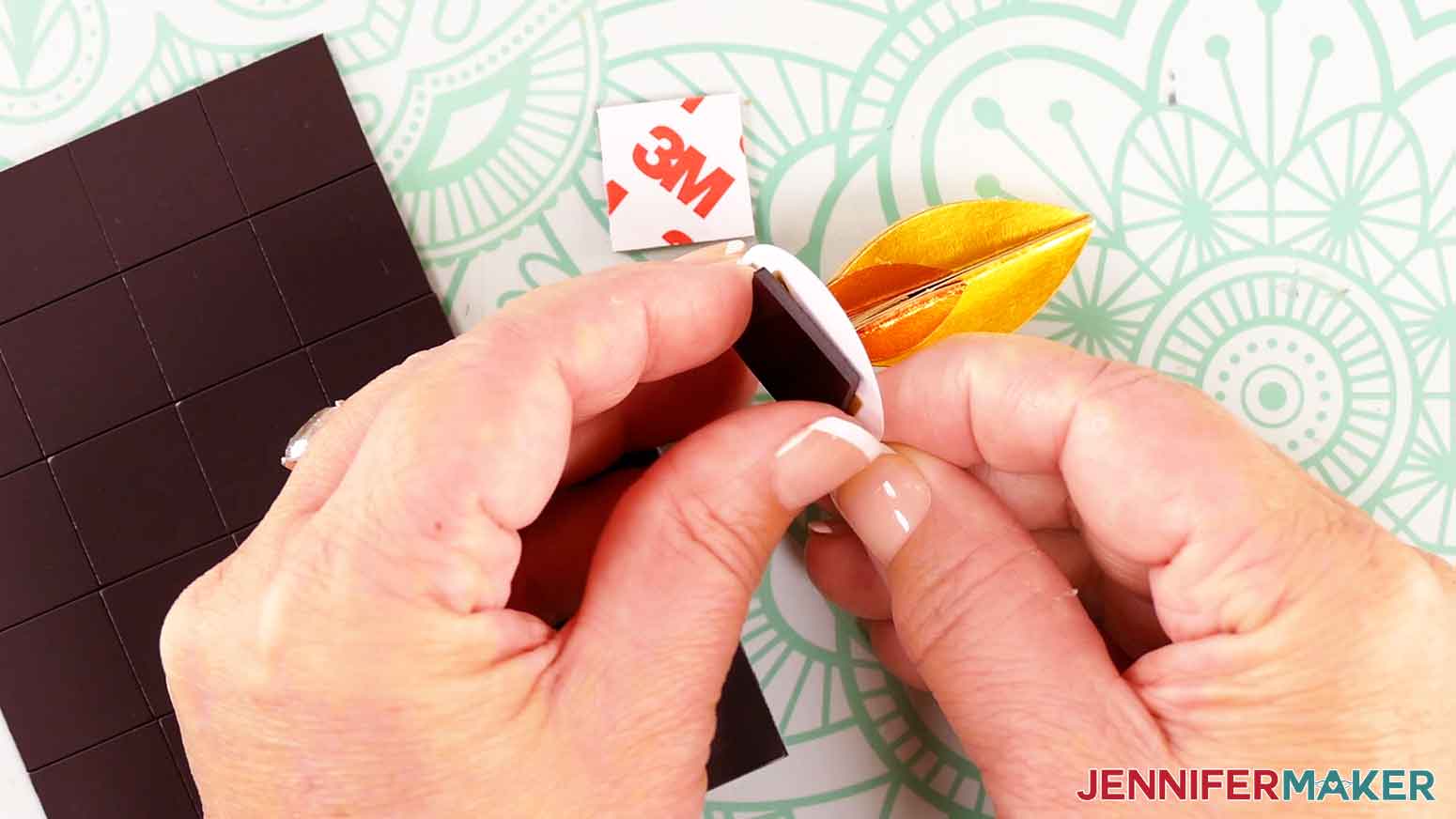 Press the sticky side of the magnetic square onto the bottom of the assembled flame and circle piece.
