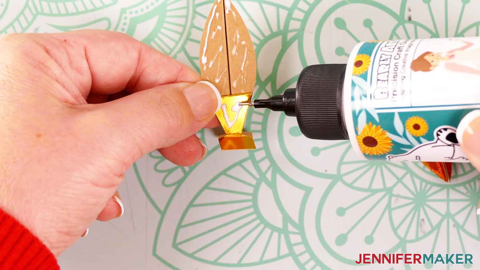 Apply glue to the exposed triangular-shaped area of the flame support piece.
