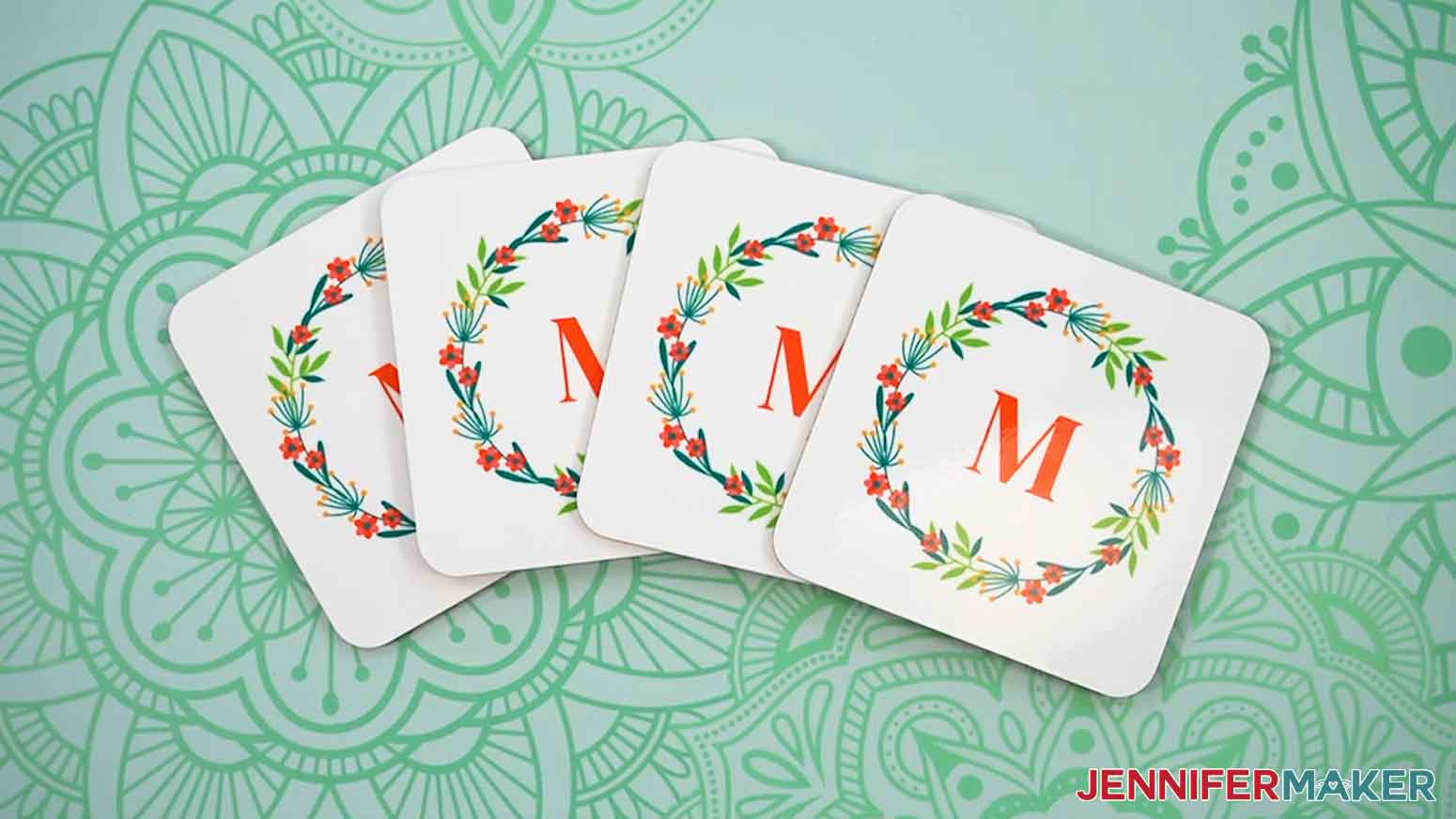 Four Canva gifts square coasters with the monogram wreath design.