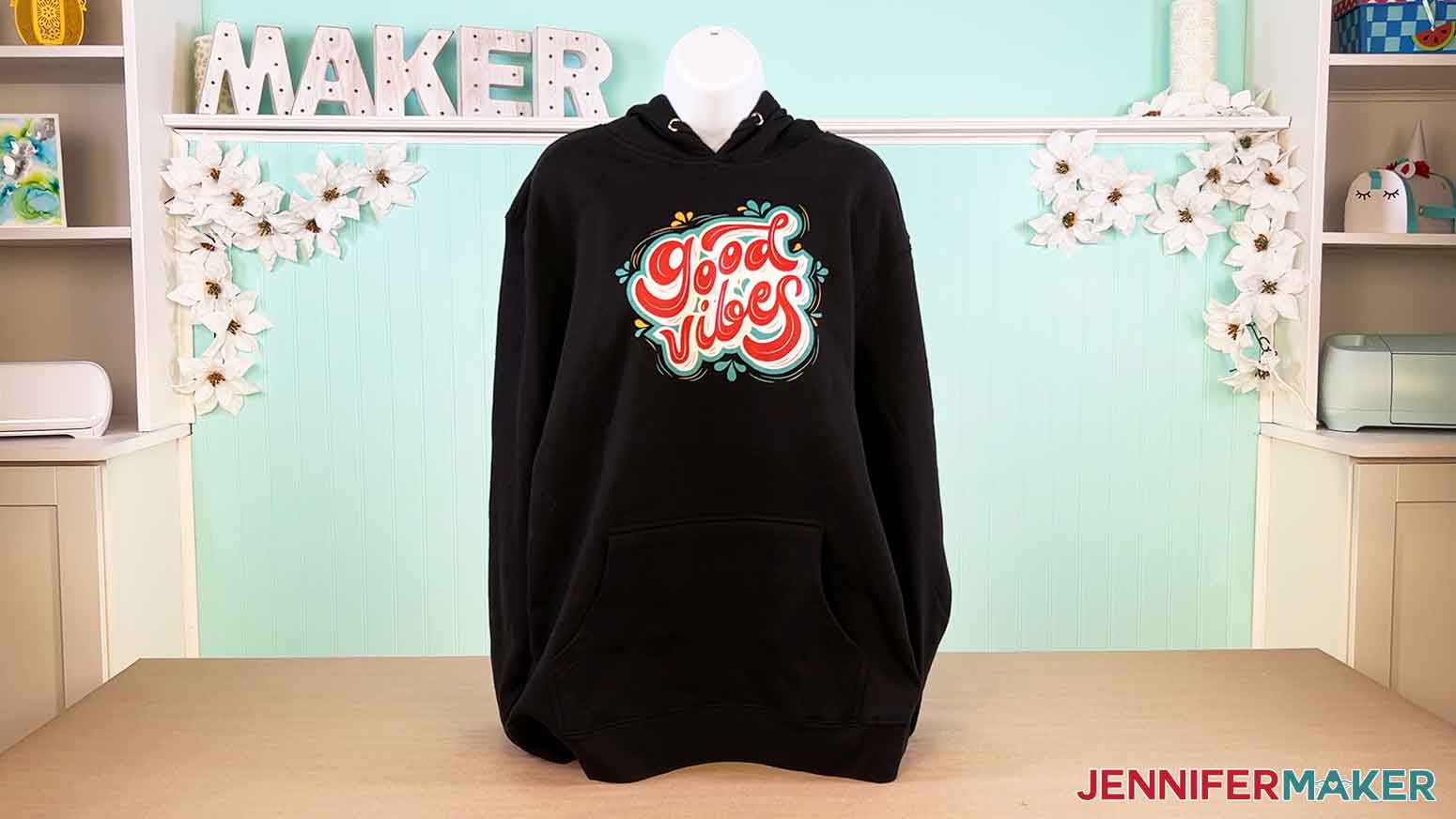 Displayed Canva gifts black hoodie with the "good vibes" design.
