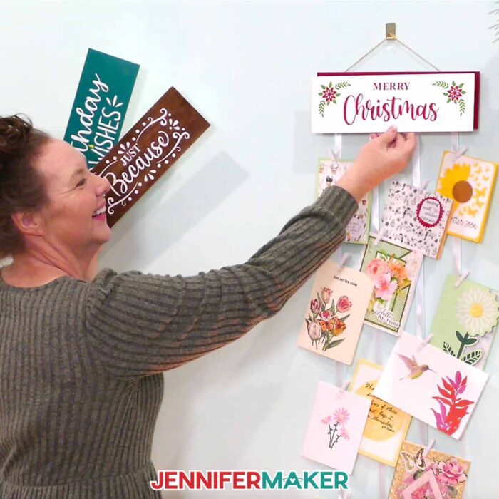 Jennifer swaps her greeting card hanger's interchangeable display panel with a "Merry Christmas" panel.