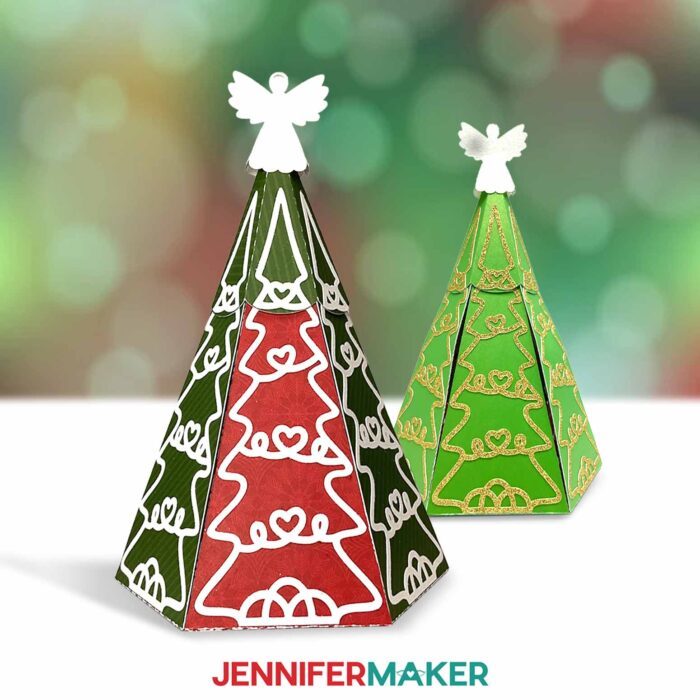 Two Christmas Tree Explosion Box projects, each with their unique shades of holiday colored cardstock, sit on display against a festive seasonal lights