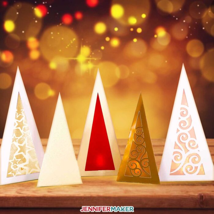 Pretty paper Christmas tree luminaries aglow against a magical backdrop