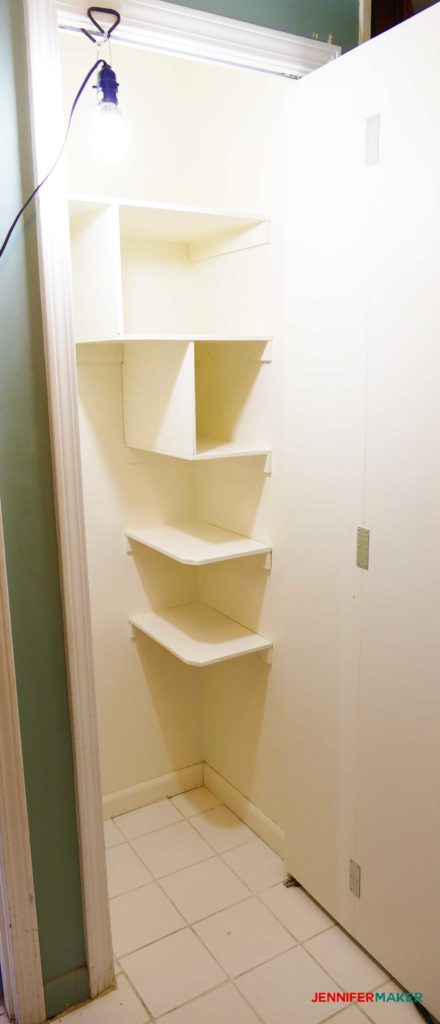 Floating shelves painted white in the cleaning closet