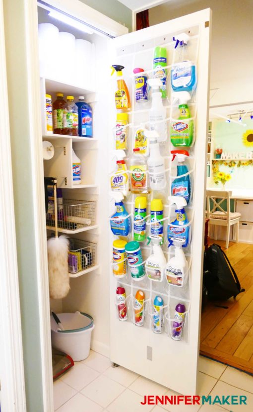 An over the door shoe holder used for cleaning supplies. A well stocked and organized cleaning closet with light, door holder, bag holders, and broom holders