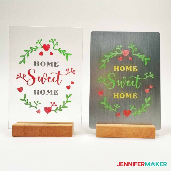 Comparison of enamel paint color engraving Home Sweet Home design on a clear acrylic plaque and metal version in wooden stands.