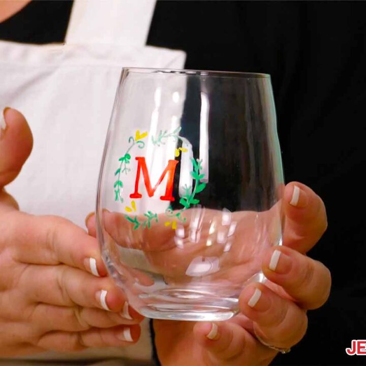 A wine glass with color glass etching of a monogram wreath