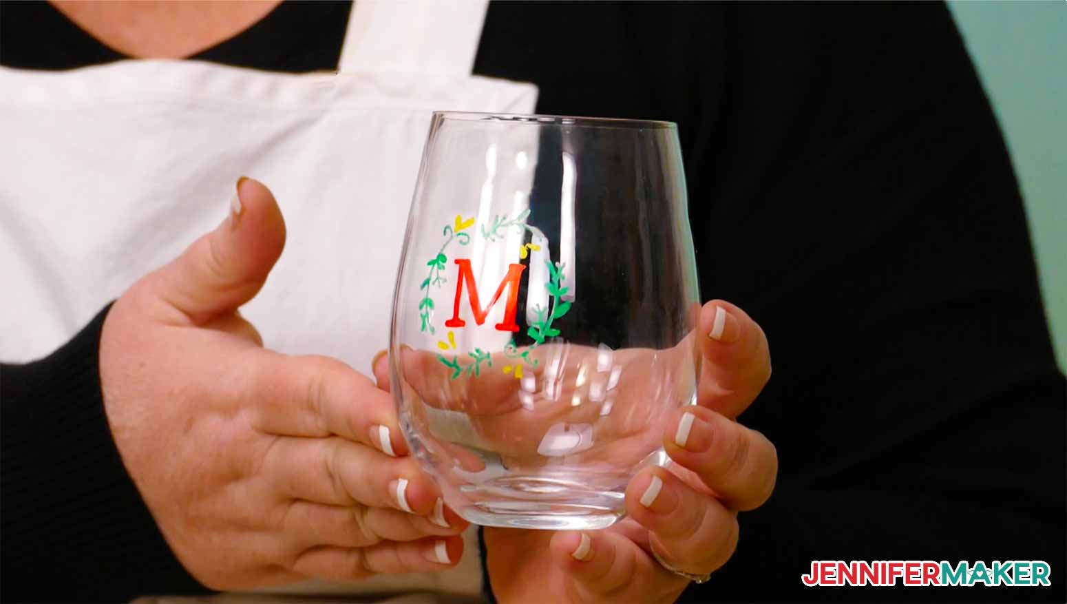 A wine glass with color glass etching of a monogram wreath