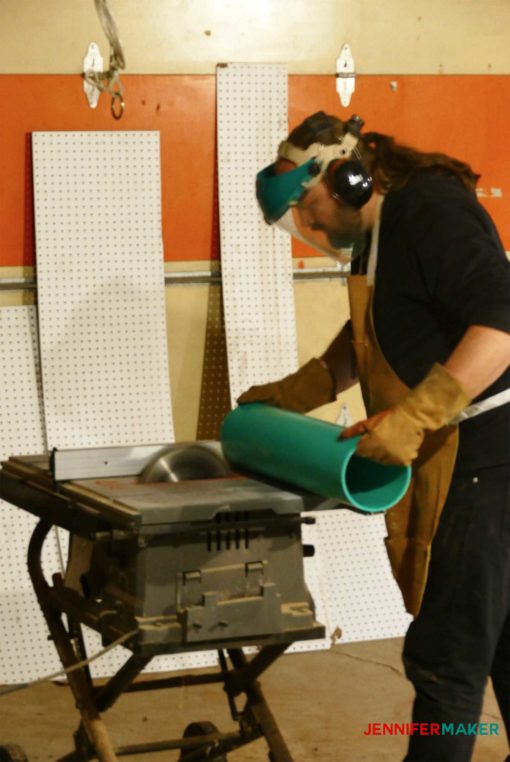 Cutting the PVC pipe to size on a table saw to make the craft paint storage organizer