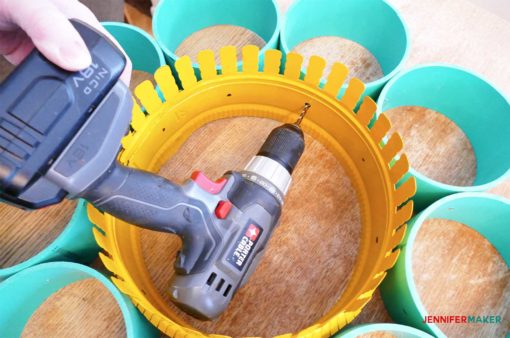 Drill through the duct collar ring and into the PVC pipe to make the craft paint storage organizer