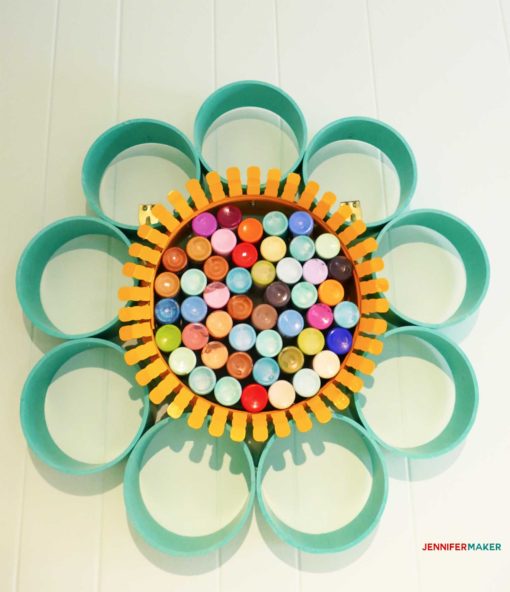 Bottles of paint in a paint storage organizer made of pvc pipe and a duct collar ring