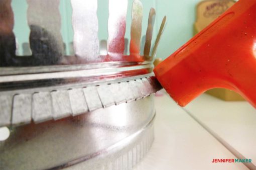 Pounding down the metal on the duct collar ring to make the craft paint storage organizer