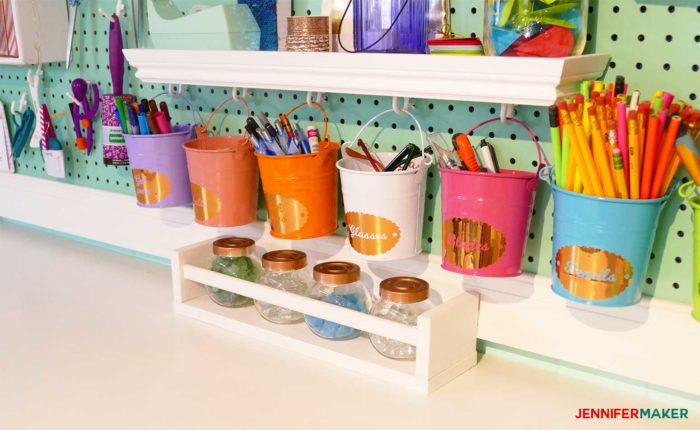 Colorful buckets hanging on my giant craft room pegboard