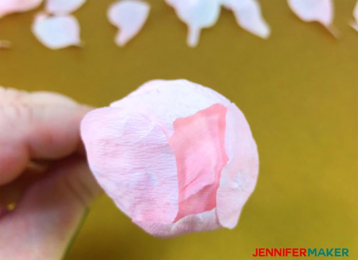 A crepe paper peony bud with petals glued around it