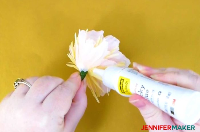 Applying glue to the base of the crepe paper peony