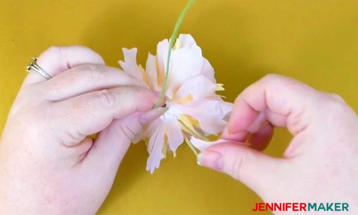 Gluing the outer petals onto the base of the crepe paper peony