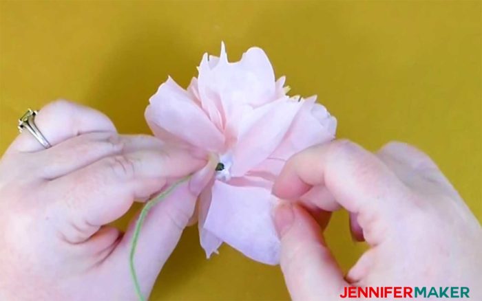Attaching the larger outer petals to the base of the crepe paper flower